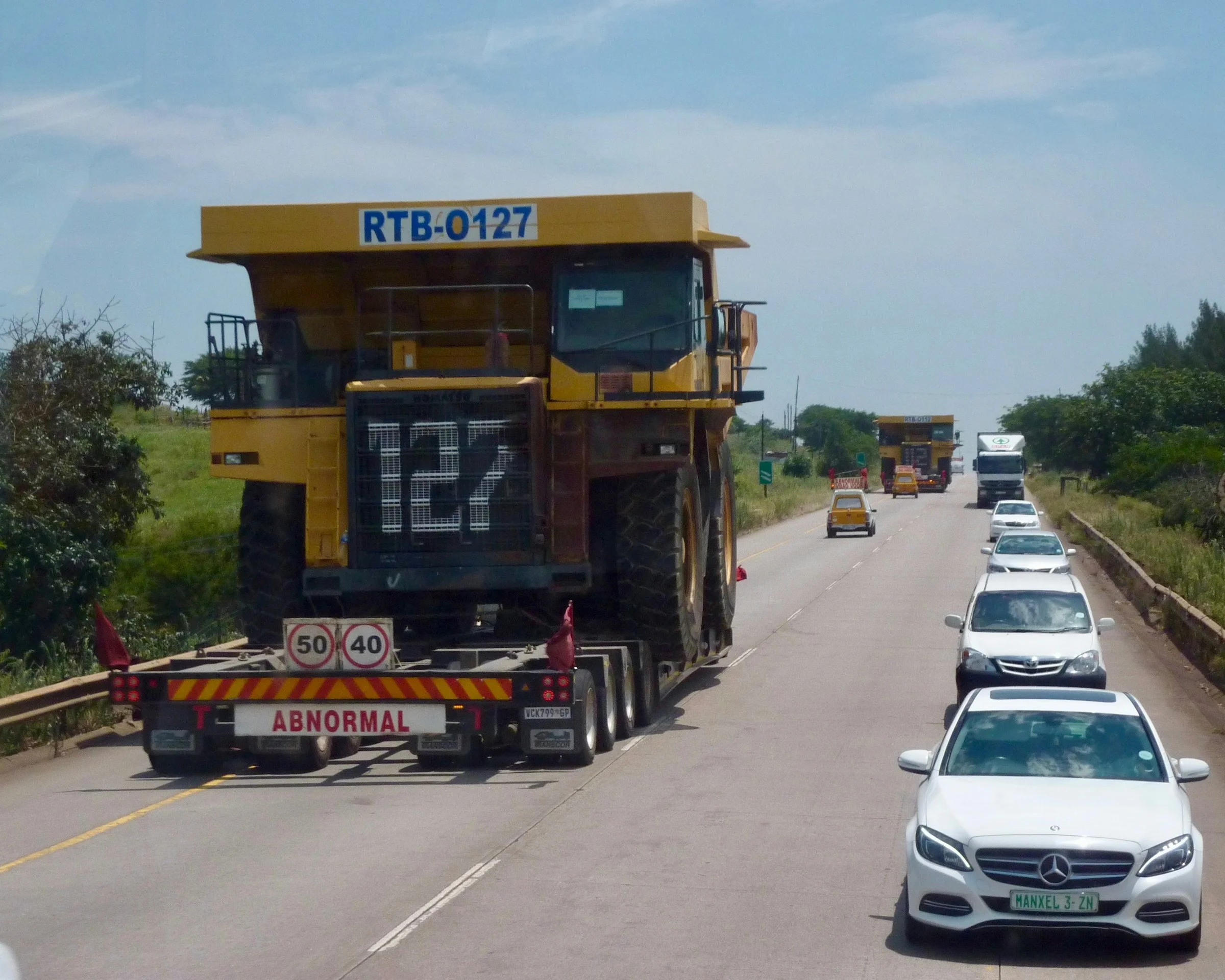 An oversized mining truck carried on a low-bed trailer