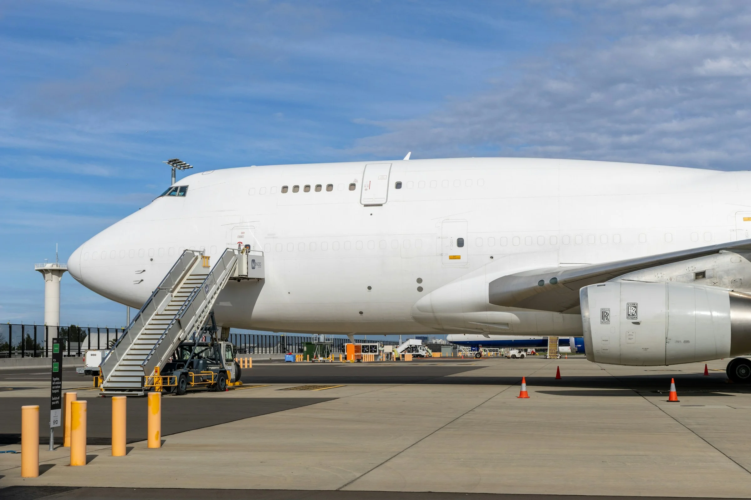 A large white freighter aircraft parked with steps at the door